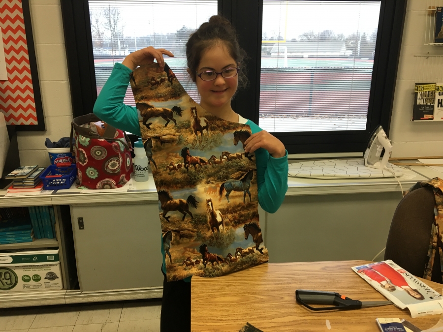 girl holding a cut pattern of fabric